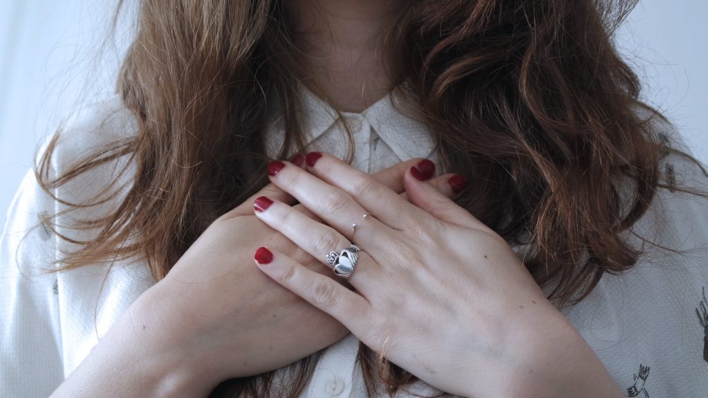 woman with both hands over heart center